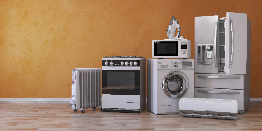 Collection of home appliances including refrigerator, stove, microwave, washing machine, dryer and space heater against orange wall