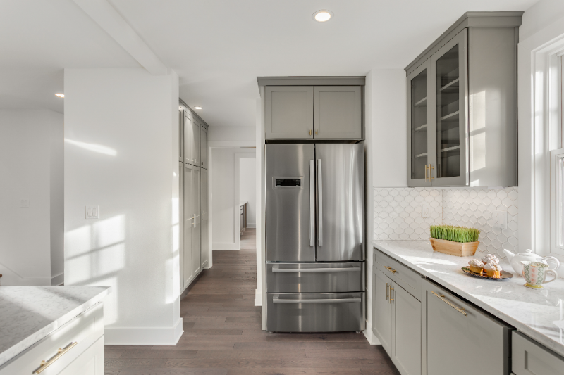 Modern kitchen with gray cabinetry, stainless steel French door refrigerator, white subway tile backsplash